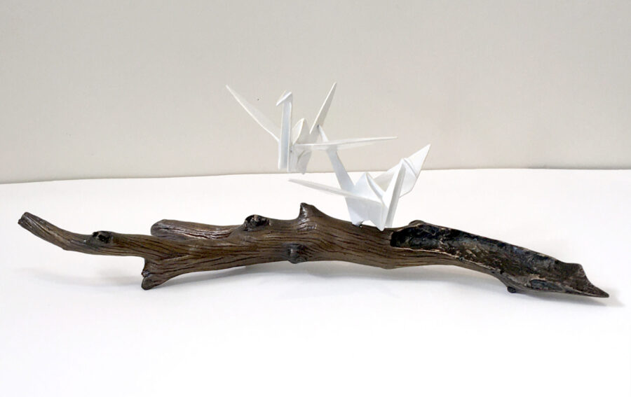 two origami cranes on branch sculpture